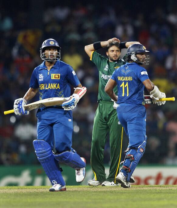 Pakistan's bowler Shahid Afridi, center, reacts as Sri Lanka's batsmen Tillakaratne Dilshan, left, and Kumar Sangakkara run between the wickets during the ICC Twenty20 Cricket World Cup semifinal match in Colombo.