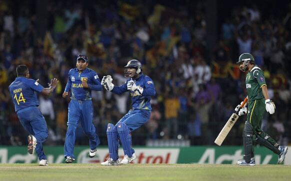 Sri Lanka's bowler Rangana Herath, left, celebrates with captain Mahela Jayawardene, second left, and wicketkeeper Kumar Sangakkara the dismissal of Pakistan's batsman Shahid Afridi, right, during the ICC Twenty20 Cricket World Cup semifinal match in Colombo.