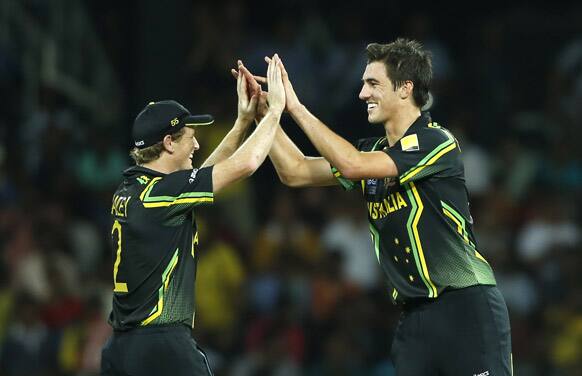 Australia's captain George Bailey, left, congratulates bowler Pat Cummins for taking the wicket of West Indies' batsman Dwayne Bravo, unseen, during the ICC Twenty20 Cricket World Cup semi final match between Australia and West Indies' in Colombo.