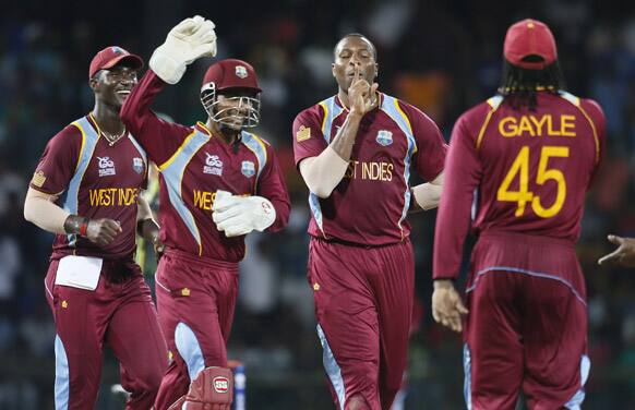 West Indies's bowler Kieron Pollard celebrates the dismissal of Australia's Pat Cummins, unseen with teammates during the ICC Twenty20 Cricket World Cup semifinal match between Australia and West Indies in Colombo.