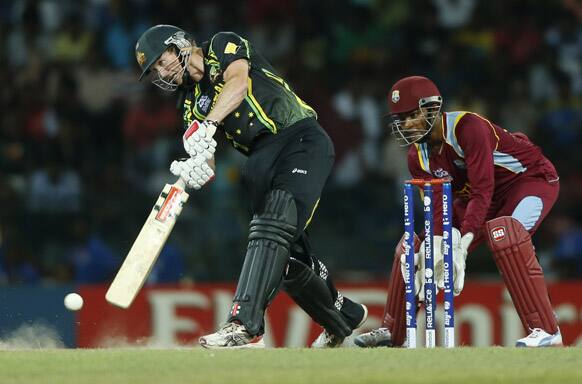 Australia's captain George Bailey, left, plays a shot as West Indies' wicketkeeper Denesh Ramdin looks on during the ICC Twenty20 Cricket World Cup semi final match between Australia and West Indies' in Colombo.