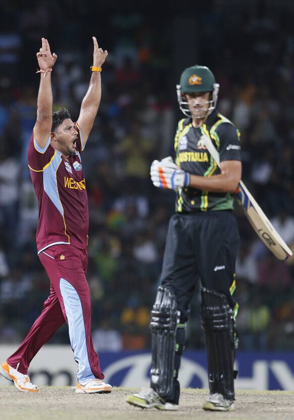 West Indies's bowler Ravi Rampaul, left, celebrates the dismissal of Australia's batsman Pat Cummins, right during the ICC Twenty20 Cricket World Cup semifinal match between Australia and West Indies in Colombo.