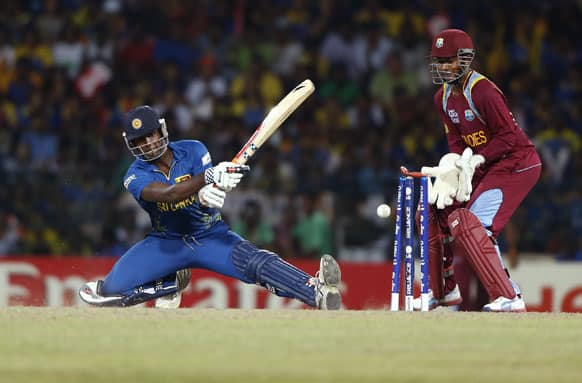 Sri Lankan batsman Angelo Mathews bowled out in front of West Indies' wicketkeeper Denesh Ramdin, right, during their ICC Twenty20 Cricket World Cup final match between Sri Lanka and West Indies' in Colombo.