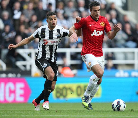 Manchester United's Robin Van Persie, right, vies for the ball with Newcastle United's Hatem Ben Arfa, left, during their English Premier League soccer match.