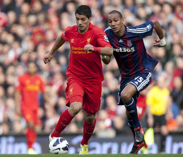 Liverpool's Luis Suarez, left, fights for the ball against Stoke's Steven N'Zonzi during their English Premier League soccer match at Anfield Stadium.