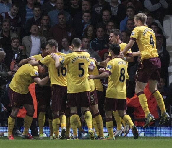 Arsenal players congratulate Santi Cazorla after scoring against West Ham United during their English Premier League soccer match at Upton Park.