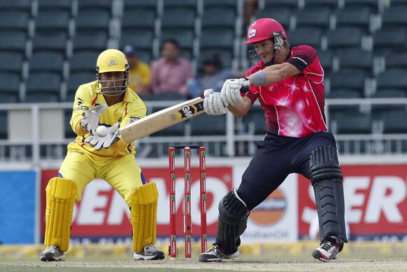 Sydney Sixers's batsman Shane Watson, right, plays a shot as Chennai Supper Kings's captain MS Dhoni, left, looks on during the Champions League Twenty20 cricket match at the Wanderers Stadium, Johannesburg.