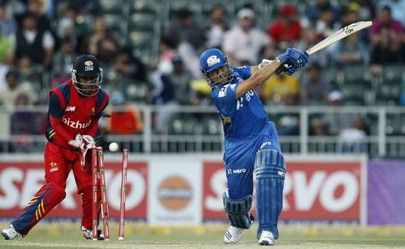 Mumbai Indians batsman Sachin Tendulkar, right, is bowled as Highveld Lions wicketkeeper Thami Tsolekile, left, looks on during the Champions League Twenty20 cricket match at the Wanderers Stadium, Johannesburg.