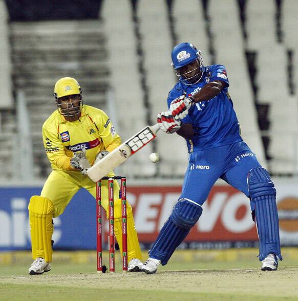 Mumbai Indians batsman Kieron Pollard, right, plays a shot as Chennai Supper Kings's captain MS Dhoni, left, looks on during their Champions League Twenty20 cricket match at the Wanderers Stadium in Johannesburg.