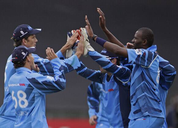 Titans' Eden Links, left, and fellow team members celebrate after Kolkata Knight Riders Manvinder Bisla, unseen, lost his wicket during a Champions League Twenty20 game in Cape Town, South Africa.