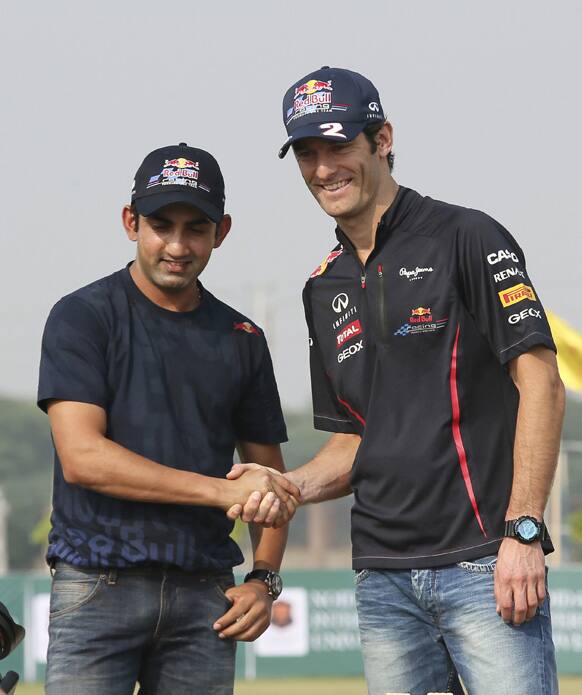 Red Bull Formula One Australian driver Mark Webber, right, shakes hands with Indian cricketer Gautam Gambhir for the benefit of the media during an F1 promotional event in Noida, on the outskirts of New Delhi.