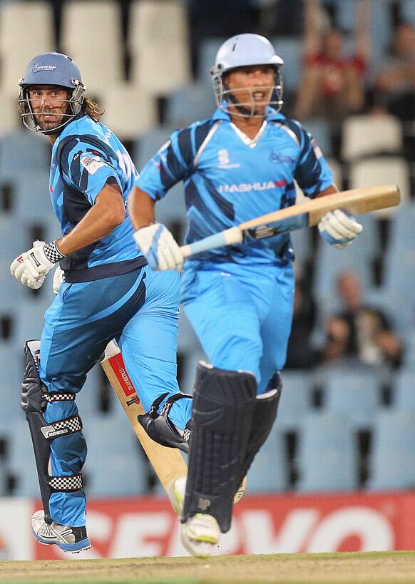 Titans's batsman David Wiese, left, with teammate Henry Davids, right, run between the wickets during the semi final of their Champions League Twenty20 cricket match against Sydney Sixers's at the Centurion Stadium in Pretoria, South Africa.