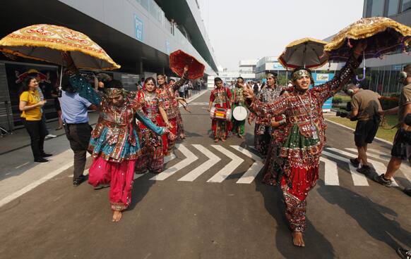 A group of Indian dancers perform in the F1 paddock prior to the start of the third practice session for the Indian Formula One Grand Prix at the Buddh International Circuit in Noida, on the outskirts of New Delhi.