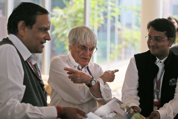 Formula One chief Bernie Ecclestone, centre, gestures as he receives a birthday gift from the Buddh International Circuit owners Sameer, right, and Manoj Gaur prior to the start of the Indian Formula One Grand Prix at the in Noida.