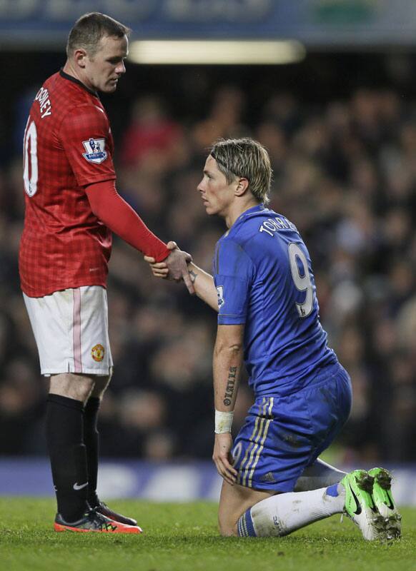 Chelsea's Fernando Torres, right, is helped up by Manchester United's Wayne Rooney after Torres receives a red card, during the English Premier League soccer match between Chelsea and Manchester United at Stamford Bridge Stadium.