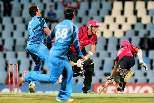 Sydney Sixers' batsman Pat Cummins, second from right, avoids Titans' bowler CJ de Villiers, left, as he makes a winning run with teammate Mitchell Starc, right, during the semifinal of their Champions League Twenty20 cricket match at the Centurion Stadium in Pretoria, South Africa.