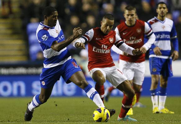 Reading's Mikele Leigertwood, left, vies for the ball with Arsenal's Theo Walcott, second from left, during the English Premier League soccer match between Reading and Arsenal at the Madejski Stadium in Reading, England, Monday, Dec. 17, 2012.