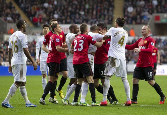 Manchester United's Robin van Persie, third right, squares up to Swansea's Ashley Williams, during their English Premier League soccer match at the Liberty Stadium in London, Sunday, Dec. 23, 2012.