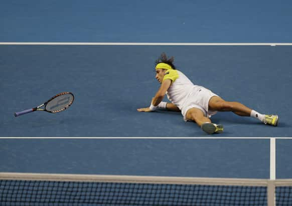 Spain's David Ferrer falls to the court during his first round match against Belgium's Oliver Rochus at the Australian Open tennis championship in Melbourne.