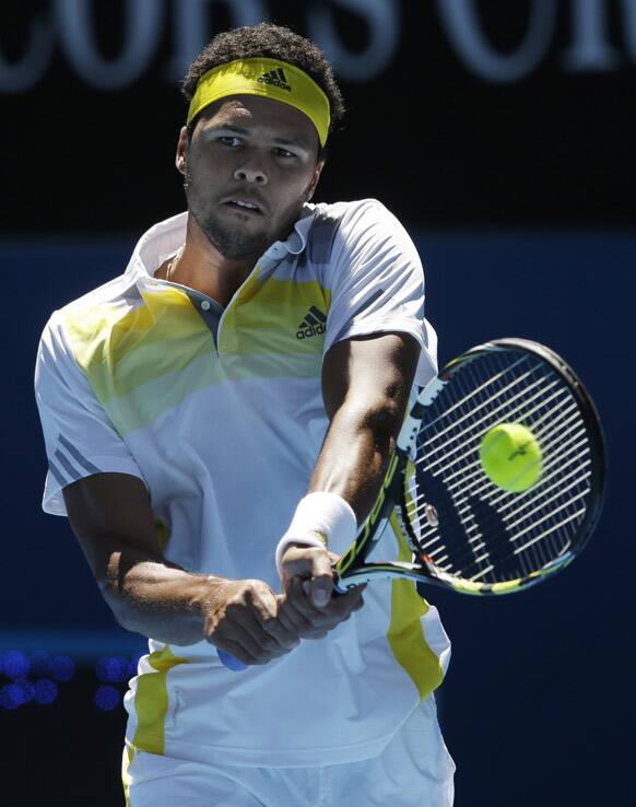 France's Jo-Wilfried Tsonga hits a backhand return to compatriot Michael Llodra during their first round match at the Australian Open tennis championship.