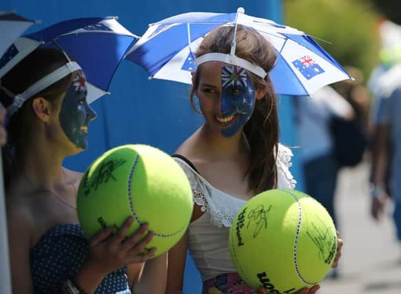 Spectators watch first round match on the outside courts at the Australian Open tennis championship.