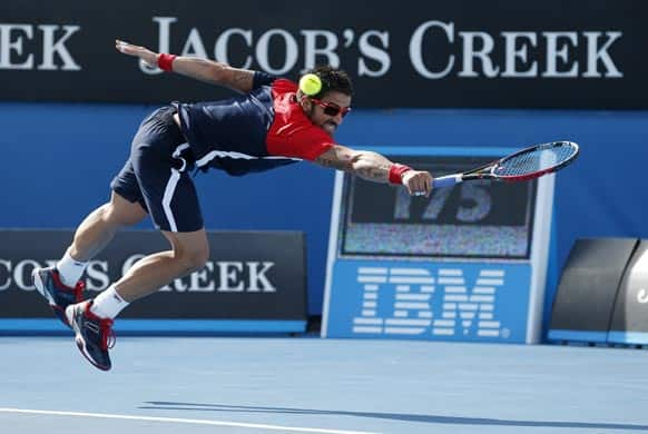 Serbia's Janko Tipsarevic makes a backhand return to France's Julien Benneteau during their third round match at the Australian Open tennis championship in Melbourne.