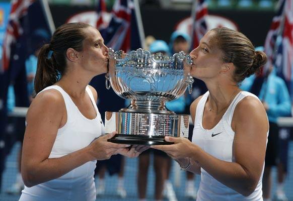 Italy's Sara Errani, right, and Roberta Vinci kiss their trophy for photographers after winning the women's doubles final against Australia's Ashleigh Barty and Casey Dellacqua at the Australian Open tennis championship in Melbourne.