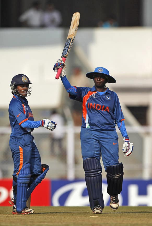 India’s Thirush Kamini Murugesan raises her bat after scoring a century against West Indies during the opening cricket match of the ICC Women's World Cup in Mumbai.