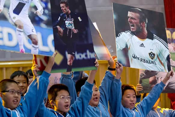 Students of Shijia Primary School rehearse their cheers before David Beckham arrives for an promotional event at their school in Beijing.