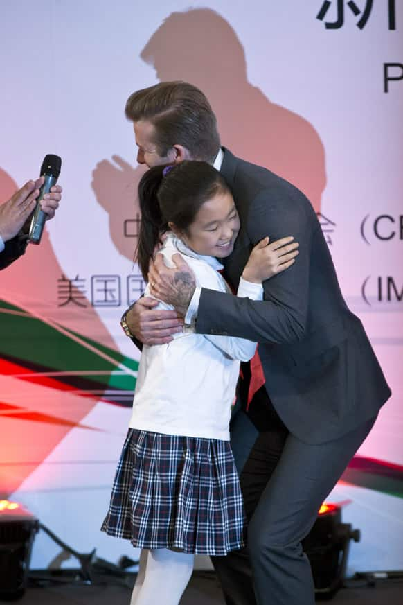 David Beckham hugs a student of Shijia Primary School during an event to promote soccer games and Chinese soccer league in Beijing.