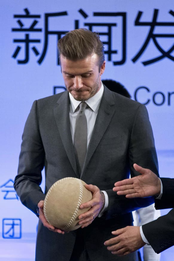 David Beckham is given a cuju ball, an ancient Chinese ball game similar to soccer, during a event to promote soccer games and Chinese soccer league at Shijia Primary School in Beijing.