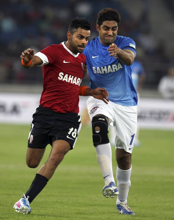 Virat Kohli and Bollywood actor Abhishek Bachchan vie for the ball during a charity soccer match played between Indian cricket players and Bollywood actors in New Delhi.