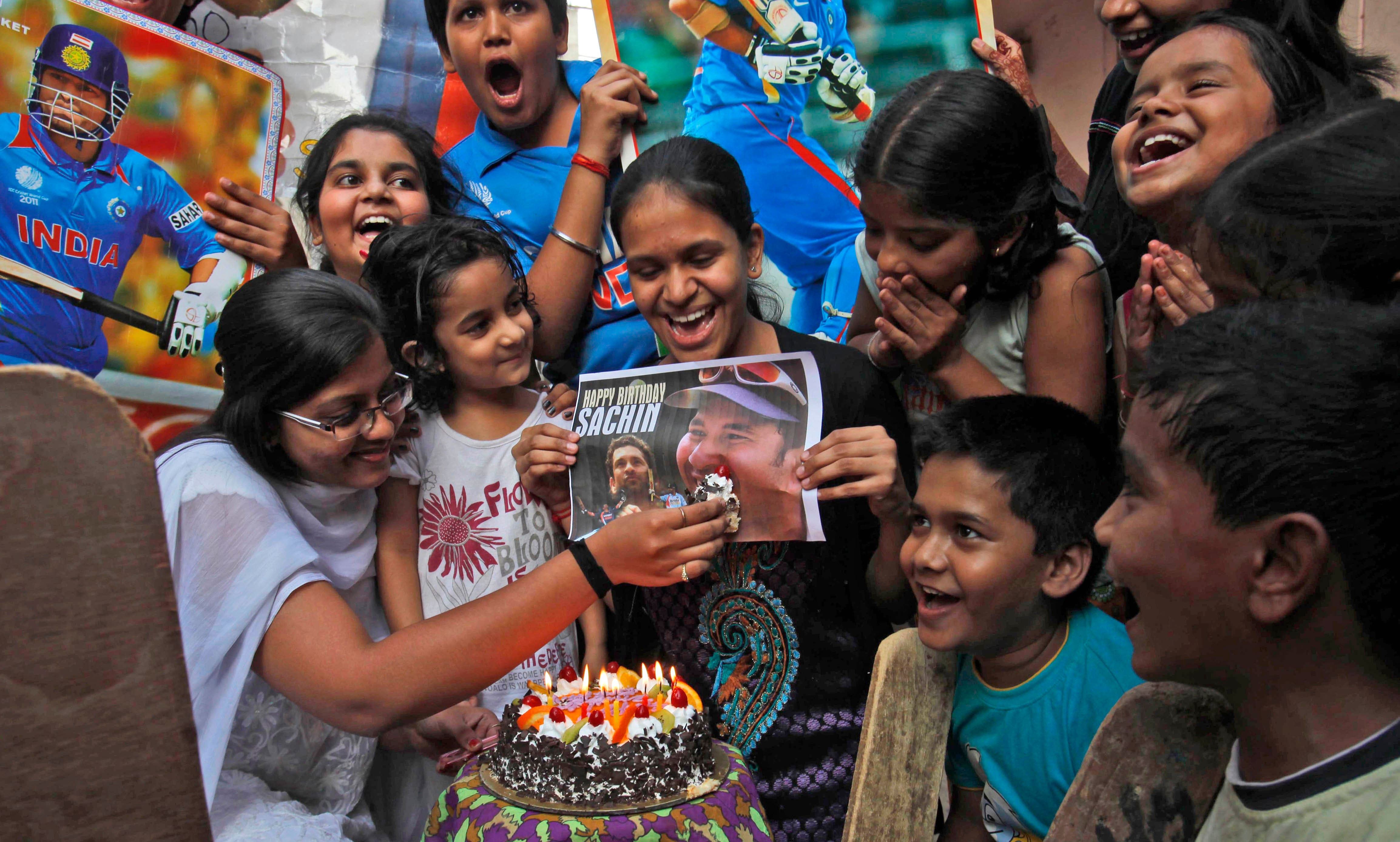 An Indian cricket fan feeds cake to a portrait of Sachin Tendulkar as they celebrate his 40th birthday in Hyderabad.