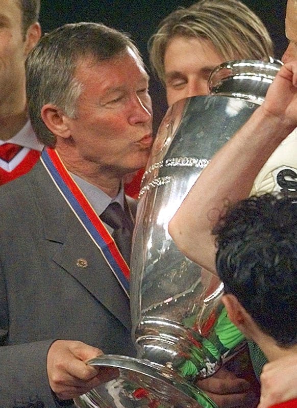 In this Wednesday, May 26, 1999 file photo Manchester United manager Alex Ferguson kisses the trophy after winning the Champions League final soccer match at the Nou Camp Stadium in Barcelona, Spain.