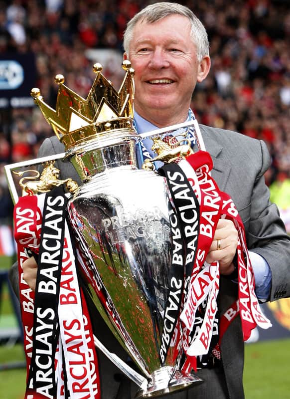 In this Saturday May 16, 2009 file photo Manchester United's manager Sir Alex Ferguson holds the English Premier League trophy as his team celebrate winning the league after their team's 0-0 draw against Arsenal at Old Trafford Stadium.