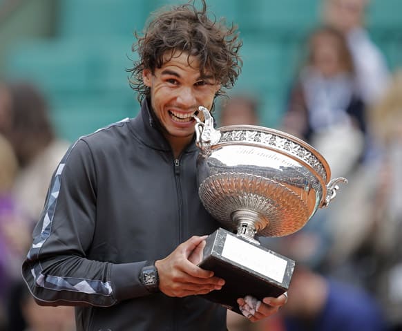 FILE In this June 11, 2012 file photo, Rafael Nadal of Spain bites the trophy after winning the mens final match against Novak Djokovic of Serbia at the French Open tennis tournament in Roland Garros stadium in Paris.