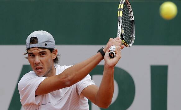 Defending champion Rafael Nadal, of Spain, returns the ball during a training session for the French Open tennis tournament at the Roland Garros stadium.