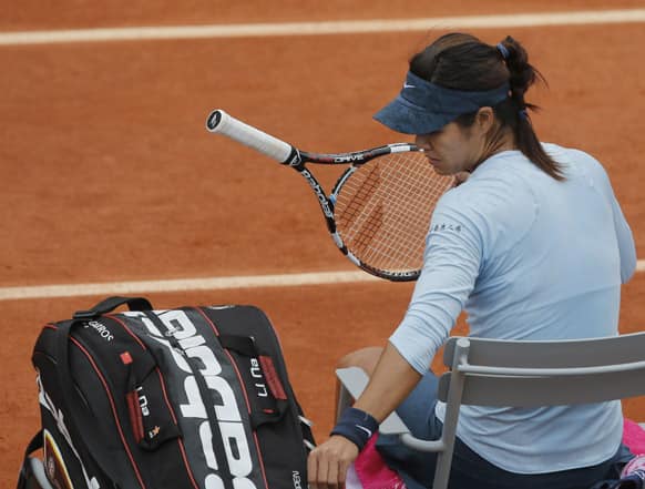 China's Li Na puts her racket away during a break because of light rain in the second round match against Bethanie Mattek-Sands of the U.S. at the French Open tennis tournament, at Roland Garros stadium in Paris. Mattek-Sands won in three sets 6-1, 5-7, 6-4.