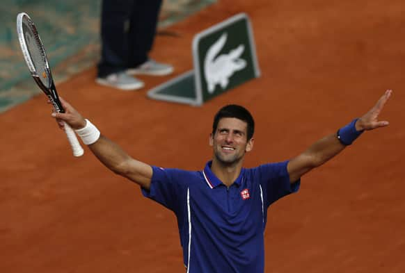 Serbia's Novak Djokovic mimics pushing the rain clouds away shortly before defeating Argentina's Guido Pella during their second round match of the French Open tennis tournament at the Roland Garros stadium in Paris. Djokovic won 6-2, 6-0, 6-2. 