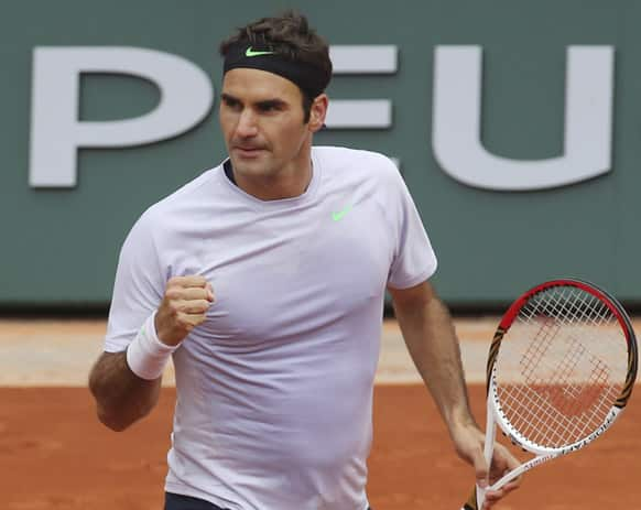 Switzerland's Roger Federer clenches his fist after scoring a point against Julien Benneteau of France in their third round match at the French Open tennis tournament, at Roland Garros stadium in Paris.