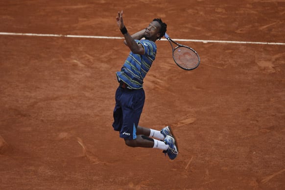 Gael Monfils of France jumps to return against Tommy Robredo of Spain in their third round match at the French Open tennis tournament, at Roland Garros stadium in Paris.