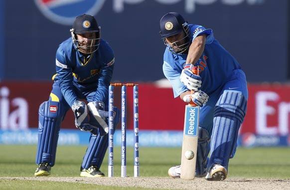 Mahendra Singh Dhoni, right, plays a shot off the bowling of Sri Lanka's Rangana Herath during their ICC Champions Trophy warm-up cricket match at Edgbaston cricket ground in Birmingham.