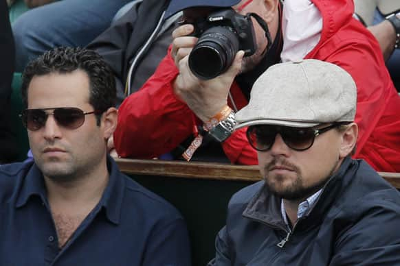 Actor Leonardo DiCaprio, right, watches the fourth round match of Switzerland's Roger Federer against France's Gilles Simon at the French Open tennis tournament, at Roland Garros stadium in Paris.