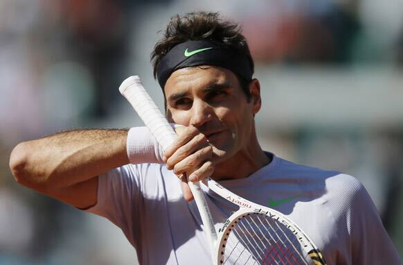 Switzerland's Roger Federer wipes his face as he plays France's Jo-Wilfried Tsonga during their quarterfinal match of the French Open tennis tournament at the Roland Garros stadium in Paris.