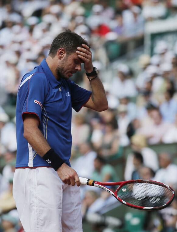 Switzerland's Stanisas Wawrinka holds his head as he plays Spain's Rafael Nadal during their quarterfinal match of the French Open tennis tournament at the Roland Garros stadium in Paris.