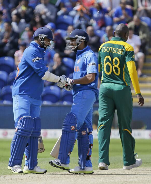 Rohit Sharma and Shikhar Dhawan meet in the middle of the pitch after Dhawan hit a 4 off South Africa's Lonwabo Tsotsobe during their group stage ICC Champions Trophy cricket match in Cardiff, Wales.