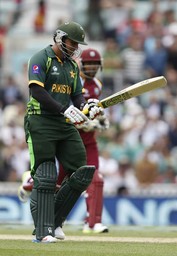 Pakistan's Nasir Jamshed walks off the crease after caught by West Indies' Ravindranath Rampaul during their ICC Champions Trophy group B cricket match at the Oval cricket ground in London.