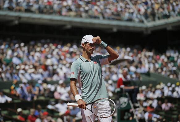 Serbia's Novak Djokovic adjusts his cap in his semifinal match against Spain's Rafael Nadal at the French Open tennis tournament, at Roland Garros stadium in Paris.