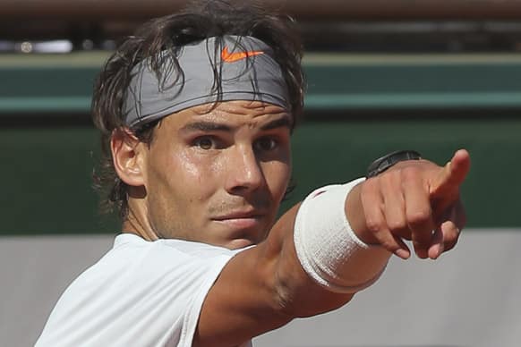 Spain's Rafael Nadal points as Serbia's Novak Djokovic touches the net when returning in the fifth set of their semifinal match at the French Open tennis tournament, at Roland Garros stadium in Paris.