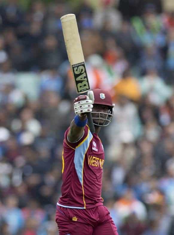 West Indies' Darren Sammy holds up his bat to acknowledge reaching 50 runs during the ICC Champions Trophy group B cricket match between India and West Indies at The Oval cricket ground in London.